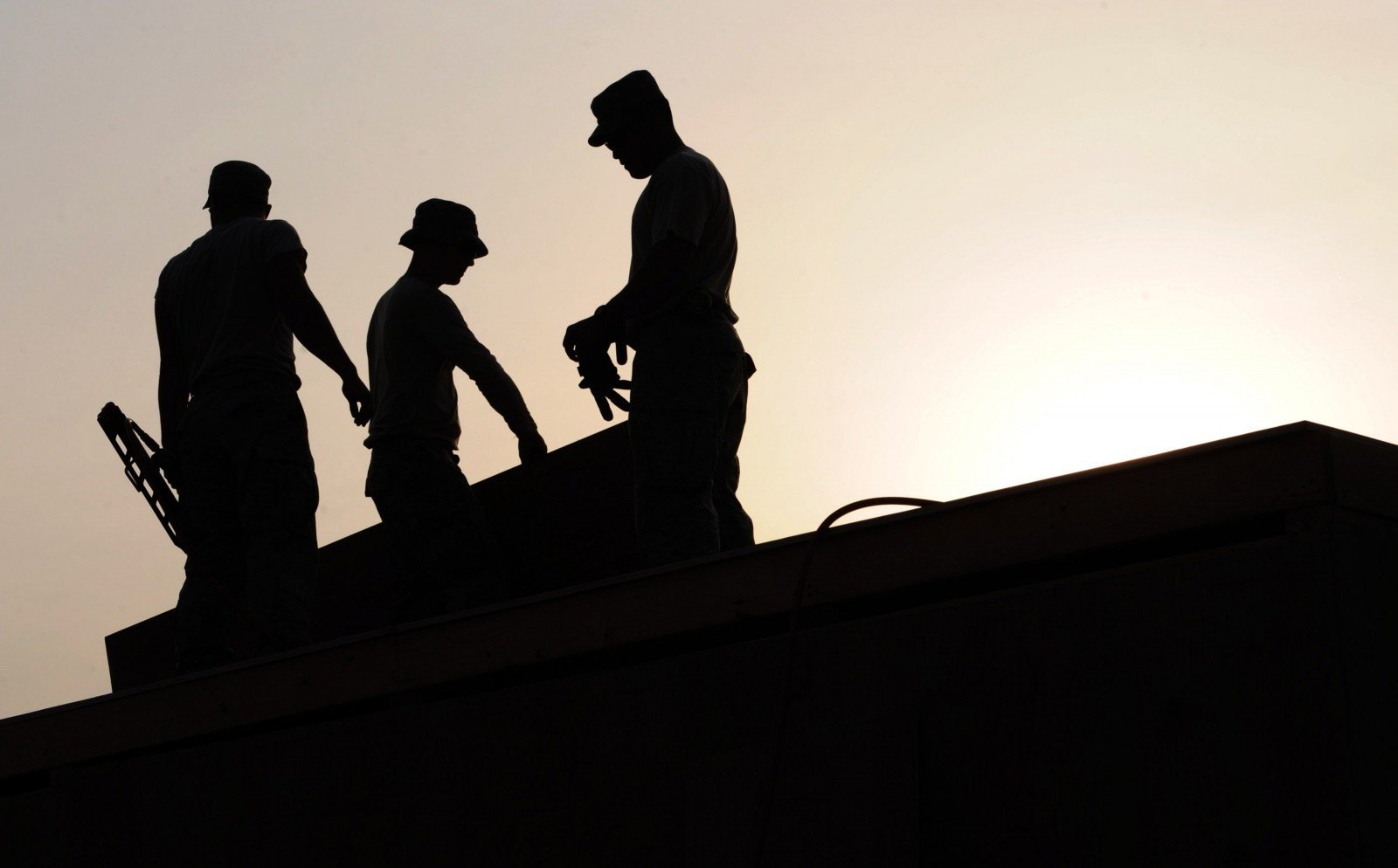 silhouette-of-workers-on-construction-site